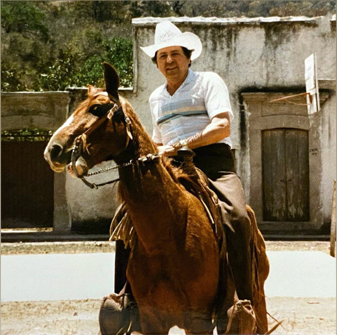 Samuel Magaña riding a horse in Mexico, wearing a cowboy hat